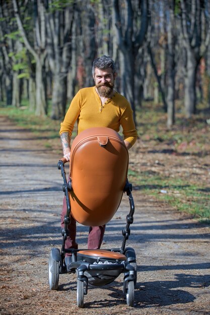 Vatertagskonzept glücklicher Mann geht Kinderwagen im Herbstpark am Vatertag der beste Vater aller Zeiten best