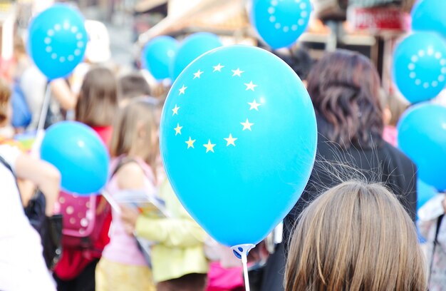 Vayamos a la UE, muchos niños con globos, personas no reconocibles