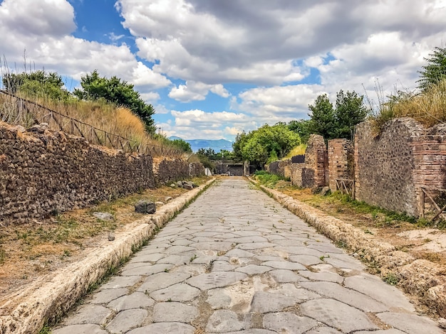 Vazia da antiga cidade romana de Pompéia, sob um céu azul com nuvens. Panorama de uma rua abandonada em Pompéia.