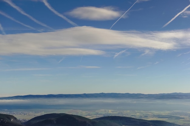 Ve a un cielo azul con nubes y un amplio valle