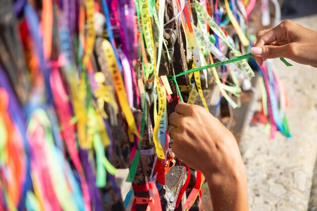 Se ve a la gente rindiendo homenaje al Senhor do Bonfim atando una cinta de recuerdo en la barandilla de hierro de las iglesias Ciudad de Salvador Bahia