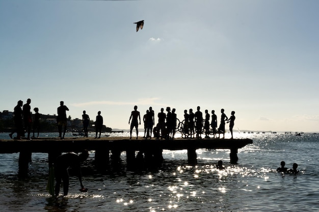 Se ve a jóvenes en silueta divirtiéndose en el puente Crush a última hora de la tarde en la ciudad de Salvador Bahia