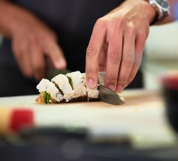 Se ve lo suficientemente bueno para comer Toma de un joven no identificable que prepara sushi en su cocina