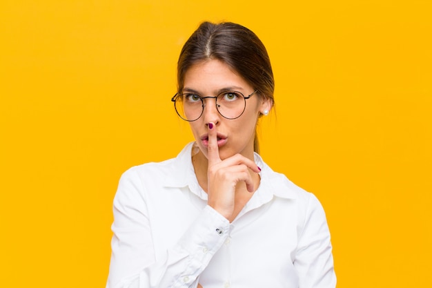 se ve serio y cruzado con el dedo presionado contra los labios exigiendo silencio o silencio, guardando un secreto