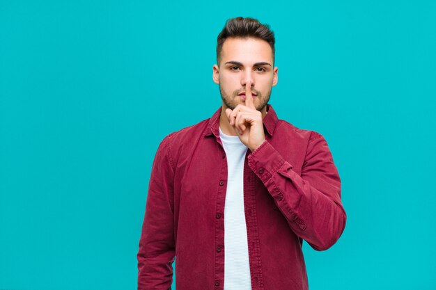 se ve serio y cruzado con el dedo presionado contra los labios exigiendo silencio o silencio, guardando un secreto