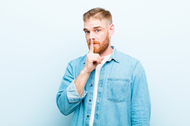 se ve serio y cruzado con el dedo presionado contra los labios exigiendo silencio o silencio, manteniendo un secreto