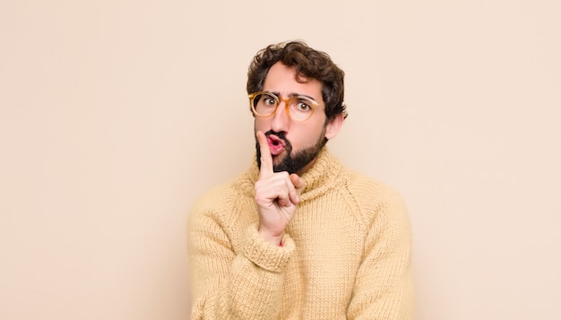 se ve serio y cruzado con el dedo presionado a los labios exigiendo silencio o silencio, guardando un secreto