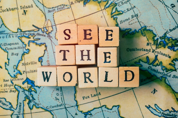 Vea el mundo escrito en bloques de madera en un mapa de viaje antiguo