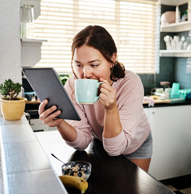 Veamos su línea de tiempo Foto de una mujer joven tomando café mientras usa una tableta digital