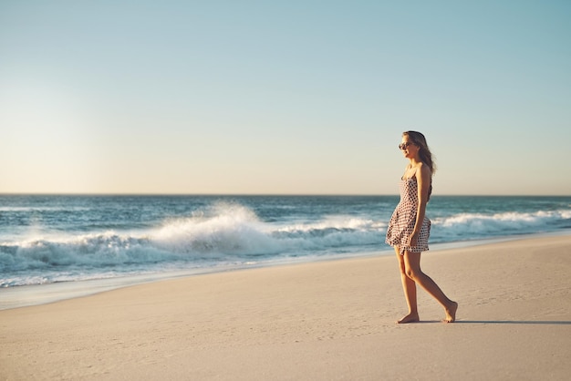 A veces la playa es todo lo que necesitas Fotografía de una mujer joven paseando por la playa