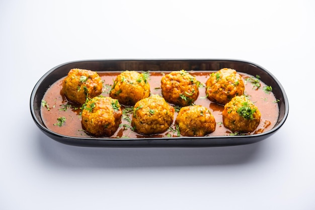 Veg Kofta Curry ist ein exotisches indisches Soßengericht aus gemischten Gemüseknödeln, die in eine Zwiebel-Tomaten-Soße getunkt werden