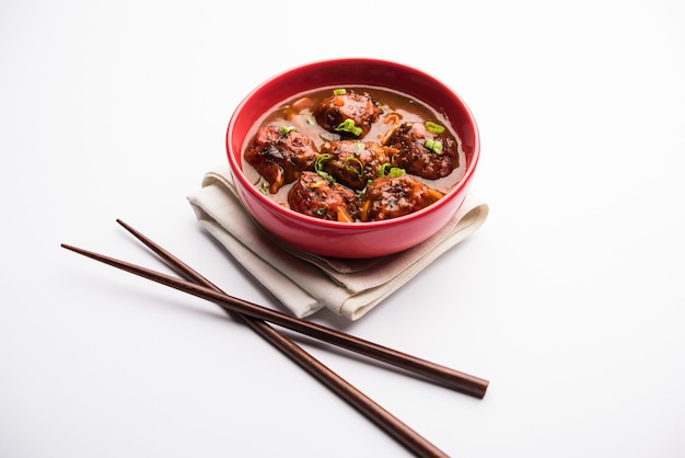 Veg ou frango manchurian com molho - comida popular da índia servida em uma tigela com pauzinho