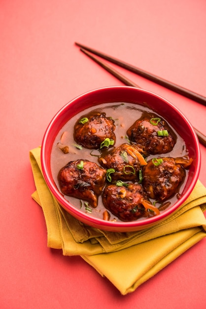 Veg ou frango Manchurian com molho - comida popular da Índia servida em uma tigela com pauzinho