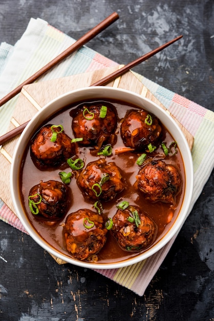 Veg ou frango Manchurian com molho - comida popular da Índia servida em uma tigela com pauzinho