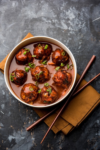 Veg ou frango Manchurian com molho - comida popular da Índia servida em uma tigela com pauzinho