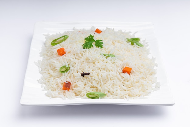 Veg Pulao elaborado con verduras de arroz basmati y especias dispuestas en una vajilla blanca cuadrada