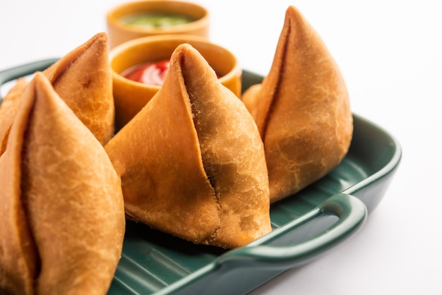 Veg Samosa - ist ein knuspriger und würziger indischer Snack in Dreiecksform mit einer knusprigen Außenschicht aus Maida und einer Füllung aus Kartoffelpüree, Erbsen und Gewürzen
