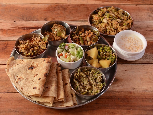 Veg Thali especial de um prato de comida de cozinha indiana consiste em variedade de pratos veggiespaneer lentilsriceroti lanches doces etc foco seletivo