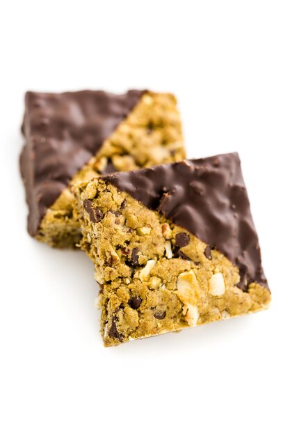 Vegan Cowgirl Squares dippen em chocolate em um fundo branco.