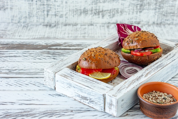 Vegan de hambúrguer caseiro cozido na hora e com salmão em fundo de madeira. Alimentos orgânicos Hralthy.