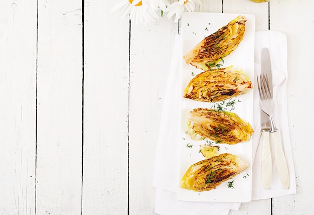 Foto vegan gegrillte kohlsteaks auf weißem hölzernem hintergrund. gesundes essen. draufsicht flach legen