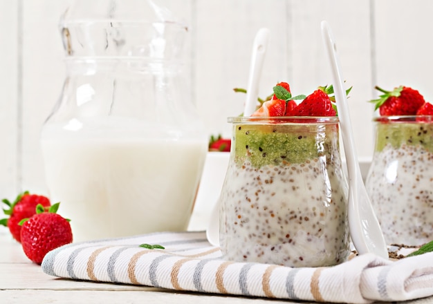 Vegan leche de coco semillas de chia pudín con fresas y kiwi.