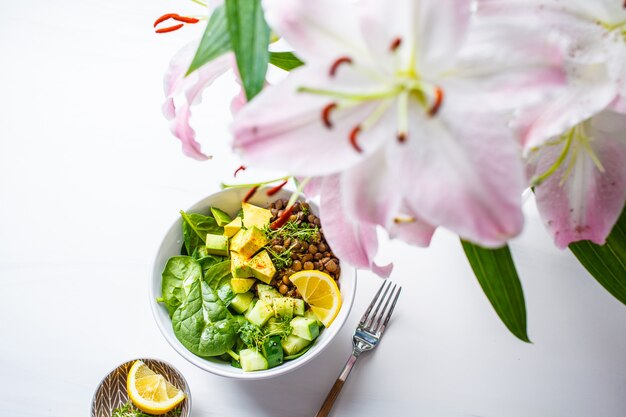 Vegan plana de ensalada verde con espinacas, lentejas, aguacate y pepino.