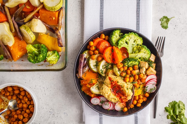 Vegan plana, tazón de Buda con verduras al horno, garbanzos, hummus y tofu.