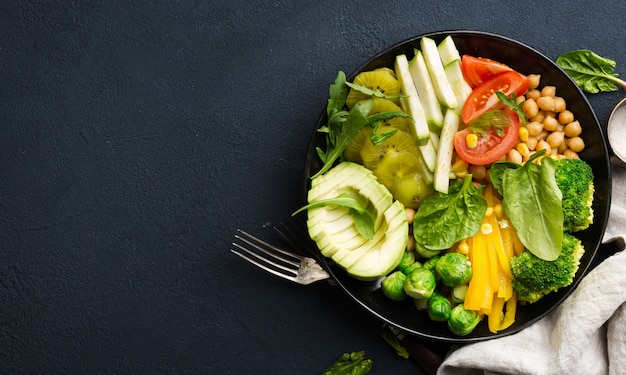 Vegane Buddha-Schale. Gesundes Ernährungskonzept. Gesundes vegetarisches Gemüsemittagessen aus Kichererbsen, Brokkoli, Pfeffer, Tomate, Spinat, Rucola und Avocado. Draufsicht