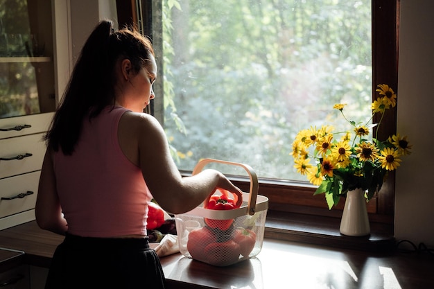 Vegane Ernährung und Gesundheit Veganer essen junge Latina-Frau, die rote Paprika in der Nähe von Gemüse auf dem Tisch hält