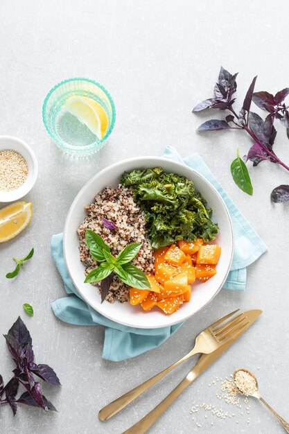 Vegane gesunde Mittagsschüssel mit sautiertem Quinoa-Grünkohl und gebackenem Butternut-Kürbis von oben nach unten