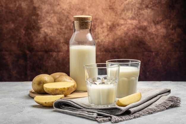 Vegane Kartoffelmilch in Glas und Rohkartoffeln Alternatives Milch-Superfood-Konzept auf pflanzlicher Basis Gesundes, sauberes Essen Vegane oder glutenfreie Ernährung Banner Menü Rezept Platz für Text