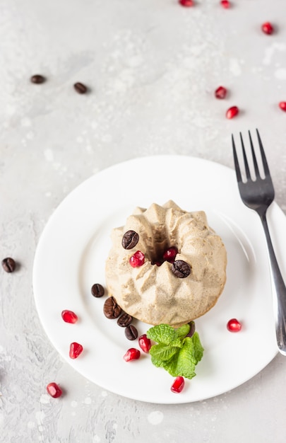 Vegane Mini-Käsekuchen mit Kaffee und Banane, garniert mit Kaffeebohnen, Granatapfel und Minze