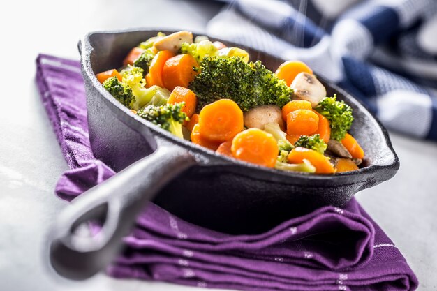 Vegane Pfanne. Vegetarisches Essen - Brokkoli-Karotten-Pilze Salzpfeffer auf Butter.