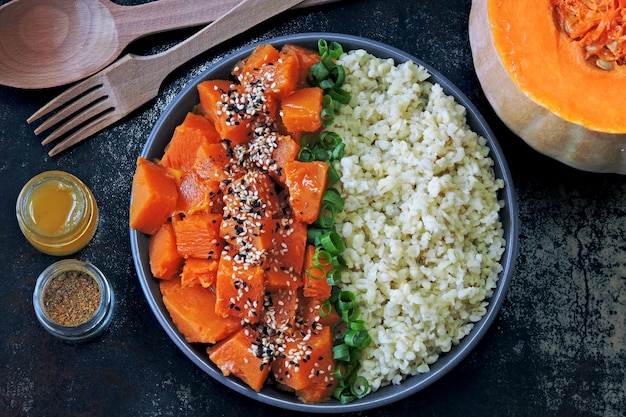 Vegane Schüssel mit Bulgur und Kürbis. Gesundes veganes Essen in einer Schüssel.