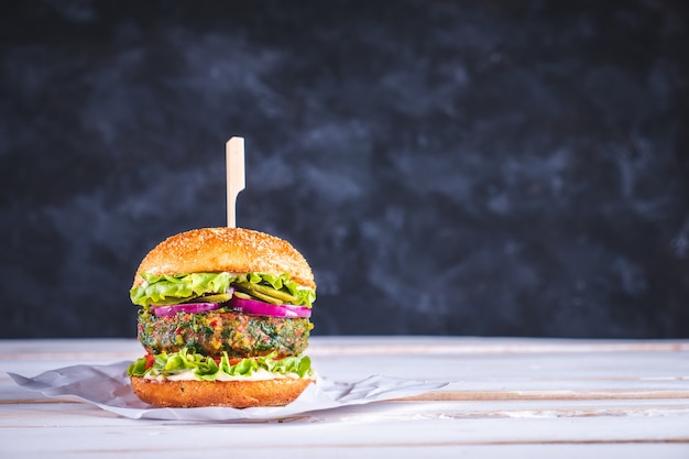 Veganer Burger auf weißem Tisch und dunkelblauem Hintergrund