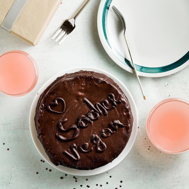 Veganer festlicher Schokoladen-Sacher-Kuchen mit Aprikosenmarmelade auf dem Tisch, geschrieben von Schokolade