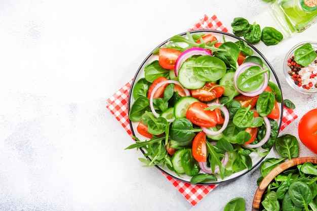 Veganer Frühlingssalat mit Spinat, Kirschtomaten, Feldsalat, Babyspinat, Gurken und roten Zwiebeln