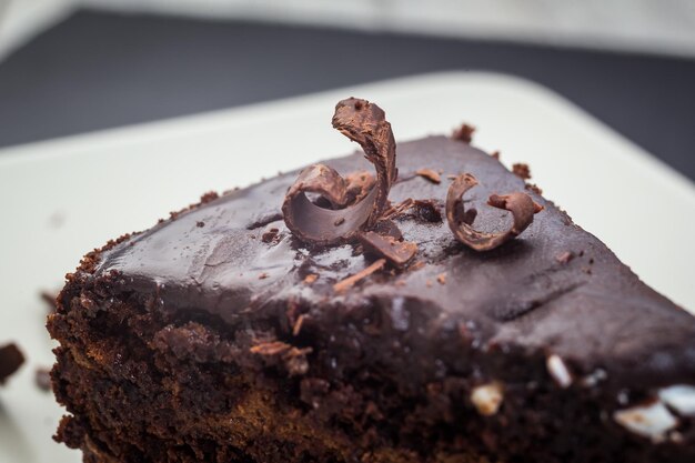 Veganer Kuchen aus dunkler Schokolade mit Süßigkeiten auf Holzhintergrund