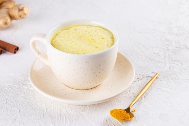 Veganer Kurkuma Golden Latte aus Mandelmilch Ingwer Kurkuma und Zimt in einer Tasse