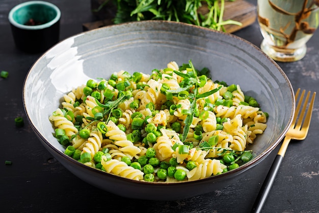 Veganer Salat. Fusilli-Nudeln mit Erbsen und Zwiebeln. Italienisches Essen.