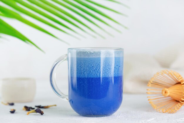 Veganes blaues Matcha-Latte-Getränk oder Anchan-Tee aus Klitorisblüten mit Kokosmilch und Palmzweig