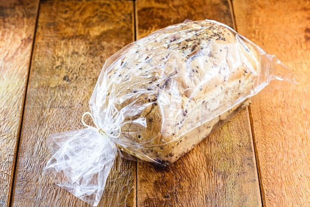 Veganes brot mit körnern in plastiktüte verpackt, handgemachtes produkt zum verkauf