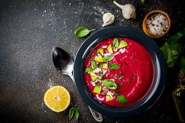 Veganes Essen, sommerkalte Rote-Bete-Gazpacho-Suppe mit Zitrone, Avocado und frischen Kräutern