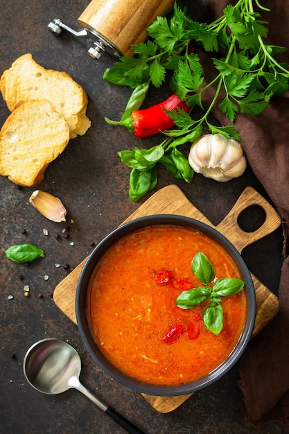 Veganes gesundes Essen Tomatensuppe oder Gazpacho auf einem dunklen Stein- oder Schiefertisch Flache Draufsicht