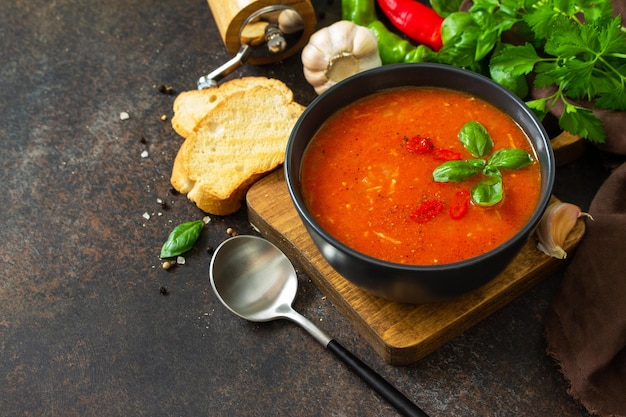 Veganes gesundes Essen Tomatensuppe oder Gazpacho auf einem dunklen Stein- oder Schiefertisch Textfreiraum