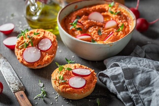 Veganes und hausgemachtes Brötchen mit rotem Hummus als gesundes Frühstück