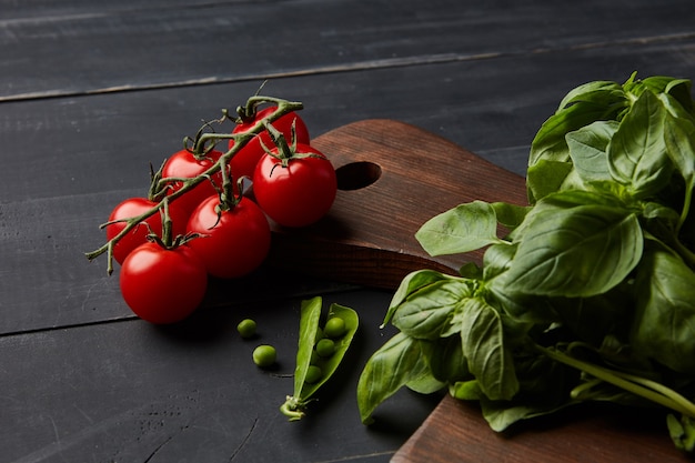 Vegetais crus diferentes frescos e especiarias em um fundo escuro de madeira. Conceito de comida orgânica saudável.