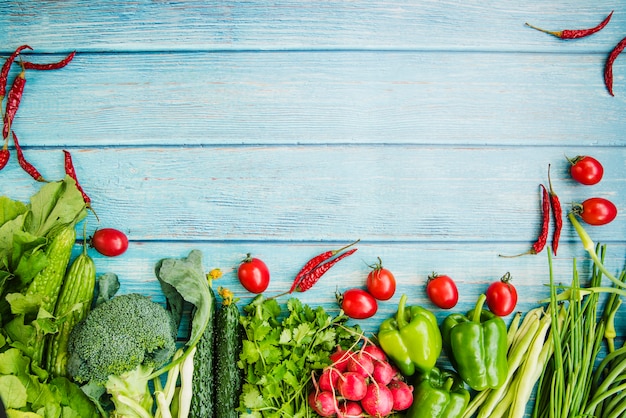 Vegetais crus diferentes na mesa de madeira azul