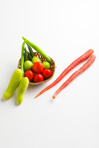 Vegetais crus em uma tigela de madeira no fundo branco